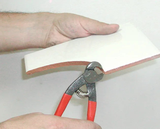 Rubi parrot-beak nippers trimming a tile edge