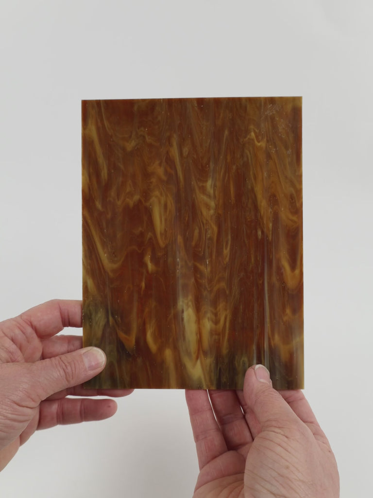 Video of the Burnt Sugar glass plate in translucent brown, 15x19cm, held up and tilted to show its pattern and transparency