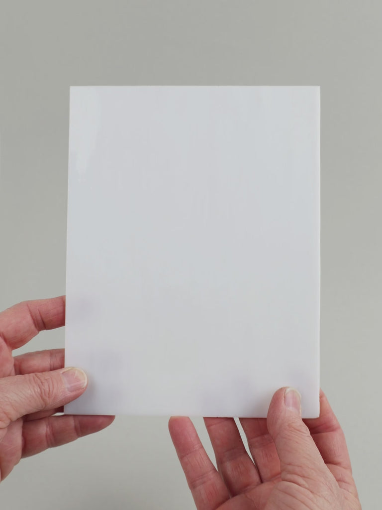Video of the white glass plate in white semi-transparant, 15x19cm, held up and tilted to show its pattern and transparency