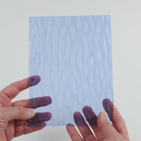 Video of the Pale Blue glass plate in ripple transparent blue, 15x19cm, held up and tilted to show its pattern and transparency