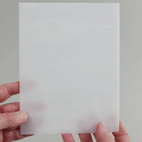 Video of the broken white glass plate in white translucent, 15x19cm, held up and tilted to show its pattern and transparency