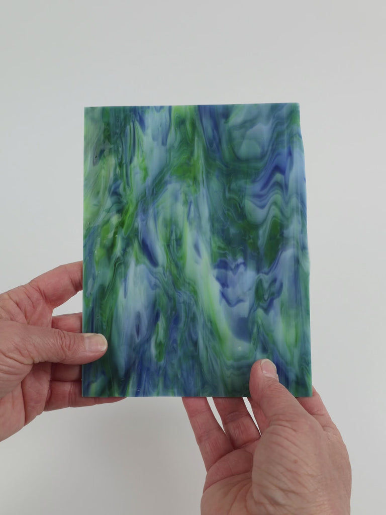 Video of the Mariposa glass plate in translucent blue, 15x19cm, held up and tilted to show its pattern and transparency