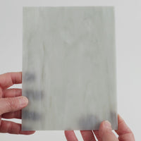 Video of the plate pewter glass plate in grey translucent marbled, 15x19cm, held up and tilted to show its pattern and transparency